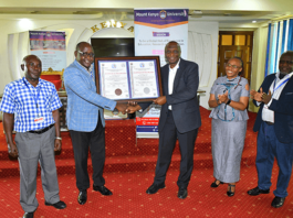 Mount Kenya University (MKU) is the first institution to be accredited to train Health Records professionals in the country after fulfilling all the requirements set by the Ministry of Health. The Director, Health Information Systems at the ministry, Mr. Gilbert Nzomo says the training of Health Records officers has come a long way as, initially, it was even done outside the country. “Many institutions are now training the officers and there is need to ensure quality. It started as a certificate programme and at the moment we have PhD programmes in the country,” he added. Speaking during the official presentation of certificate of accreditation to MKU, the Chairman, Health Records and Information Mangers Board, Mr. Onesmus K. Mwaura said MKU was the first institution to be accredited after fulfilling all the requirements. “As a board, we have embarked on streamlining the training of the health records and information officers in the country. One way of ensuring that all the institutions adhere to the set guidelines is through accreditation,” he said. Mr Mwaura said the Health Records and Information Managers Board (HRIM) is anchored in the HRIM Act No 15 of 2016 which became operational in 2022. “The act empowers the board to exercise regulatory and oversight roles on training institutions offering training in Health Records and Information courses,” he added. MKU vice-chancellor Prof. Deogratius Jaganyi, expressed gratitude to the Health Records and Information Managers Board (HRIMB) for the collaboration with his institution in the training of Health Records and Information Managers. “Universal access to quality health services and, in turn, improved health outcomes require not only more health professionals but also the quality and relevance of education in health professions,” he said. Accordingly, plans are underway to the process of launching a Master of Health Information Management Program. “MKU values the strong collaborative relationship that we share with the HRIM Board and remains committed to upholding the highest standards of training Health Records and Information management managers,” he added. MKU graduated its first Bachelor of Science in Health Records and Information Management graduates in December 2012. To date, the university has graduated 516 Bachelor of Science, 860 Diplomas and 383 certificates in Health Records and Information Management. “Our health records and information technology graduates are making an impact in diverse sectors including the government, Non-governmental Organisations, academia, and international bodies such the World Health Organisation,” noted the VC. Prof Jaganyi noted that the university remains committed to preparing the students to high quality professionals to serve as health care and quality managers at all levels of the healthcare ecosystem both locally and internationally. “Our programmes endeavour to expose our graduates to modern technology in the health records domain which ensures that they are capable of applying technology in the improvement of patient care and outcomes,” he added. Others who attended or were represented at the function were MKU’s Deputy Vice-Chancellor, Academic and Research Affairs, Dr Mercyline Kamande; Registrar, Academic Administration, Dr Ronald Maathai; Principal, College of Health Sciences, Dr. Josphat Njuguna; Dean, School of Clinical Medicine, Mr. Peter Mwaura, faculty members and students. The news of the certification comes a few days after the university was re-accredited by the Nursing Council of Kenya to continue training nursing students. The Institution has been offering a Bachelor of Science in Nursing degree for the last 12 years and has been subject to regular reviews by the nursing council to confirm that the university’s facilities, including laboratories, meet the set requirements. The reviews undertaken every five years are a legal requirement for all institutions of higher learning training nursing students. The Registrar Nursing Council of Kenya Dr. Lister Onsongo presented the re-accreditation certificate to the MKU Vice-Chancellor Prof. Deogratious Jaganyi.