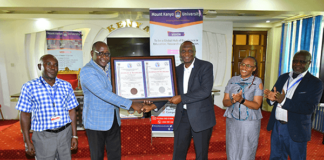 Mount Kenya University (MKU) is the first institution to be accredited to train Health Records professionals in the country after fulfilling all the requirements set by the Ministry of Health. The Director, Health Information Systems at the ministry, Mr. Gilbert Nzomo says the training of Health Records officers has come a long way as, initially, it was even done outside the country. “Many institutions are now training the officers and there is need to ensure quality. It started as a certificate programme and at the moment we have PhD programmes in the country,” he added. Speaking during the official presentation of certificate of accreditation to MKU, the Chairman, Health Records and Information Mangers Board, Mr. Onesmus K. Mwaura said MKU was the first institution to be accredited after fulfilling all the requirements. “As a board, we have embarked on streamlining the training of the health records and information officers in the country. One way of ensuring that all the institutions adhere to the set guidelines is through accreditation,” he said. Mr Mwaura said the Health Records and Information Managers Board (HRIM) is anchored in the HRIM Act No 15 of 2016 which became operational in 2022. “The act empowers the board to exercise regulatory and oversight roles on training institutions offering training in Health Records and Information courses,” he added. MKU vice-chancellor Prof. Deogratius Jaganyi, expressed gratitude to the Health Records and Information Managers Board (HRIMB) for the collaboration with his institution in the training of Health Records and Information Managers. “Universal access to quality health services and, in turn, improved health outcomes require not only more health professionals but also the quality and relevance of education in health professions,” he said. Accordingly, plans are underway to the process of launching a Master of Health Information Management Program. “MKU values the strong collaborative relationship that we share with the HRIM Board and remains committed to upholding the highest standards of training Health Records and Information management managers,” he added. MKU graduated its first Bachelor of Science in Health Records and Information Management graduates in December 2012. To date, the university has graduated 516 Bachelor of Science, 860 Diplomas and 383 certificates in Health Records and Information Management. “Our health records and information technology graduates are making an impact in diverse sectors including the government, Non-governmental Organisations, academia, and international bodies such the World Health Organisation,” noted the VC. Prof Jaganyi noted that the university remains committed to preparing the students to high quality professionals to serve as health care and quality managers at all levels of the healthcare ecosystem both locally and internationally. “Our programmes endeavour to expose our graduates to modern technology in the health records domain which ensures that they are capable of applying technology in the improvement of patient care and outcomes,” he added. Others who attended or were represented at the function were MKU’s Deputy Vice-Chancellor, Academic and Research Affairs, Dr Mercyline Kamande; Registrar, Academic Administration, Dr Ronald Maathai; Principal, College of Health Sciences, Dr. Josphat Njuguna; Dean, School of Clinical Medicine, Mr. Peter Mwaura, faculty members and students. The news of the certification comes a few days after the university was re-accredited by the Nursing Council of Kenya to continue training nursing students. The Institution has been offering a Bachelor of Science in Nursing degree for the last 12 years and has been subject to regular reviews by the nursing council to confirm that the university’s facilities, including laboratories, meet the set requirements. The reviews undertaken every five years are a legal requirement for all institutions of higher learning training nursing students. The Registrar Nursing Council of Kenya Dr. Lister Onsongo presented the re-accreditation certificate to the MKU Vice-Chancellor Prof. Deogratious Jaganyi.