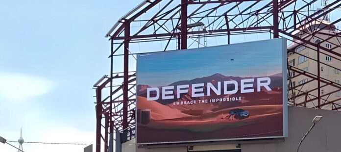 Polygon (https://PDOOH.co.za/), Africa’s leading and largest programmatic aggregated digital out-of-home (DOOH) publisher network has launched its first programmatic DOOH (pDOOH) campaign in Kenya for luxury automotive brand Jaguar Land Rover (JLR). The campaign, executed in partnership with Polygon’s technology provider Place Exchange and media agency Omnicom Media Group (OMG), celebrates JLR’s 55-year anniversary and showcases the latest Defender model. However, it also represents another important milestone for the Kenyan advertising landscape, as the first locally-activated pDOOH campaign to run through Google-based trading tools. “This is a watershed moment for both the Kenyan and broader African DOOH markets, says Remi du Preez, Managing Director at Polygon. “It demonstrates how international brands can now transact programmatically across our network using the same digital platforms they rely on globally, bringing true omnichannel capability to Africa.” The JLR campaign currently focuses on Nairobi, targeting affluent suburbs, upmarket malls and Jomo Kenyatta International Airport. Initially launched across a limited number of sites, the rollout will soon expand to around 50 premium screens. While Kenya’s OOH market is smaller than South Africa’s, it remains one of Africa’s top five regions for outdoor media, with a fast-growing digital footprint and increasing advertiser appetite, says Du Preez. “The local market’s sentiment toward DOOH has shifted dramatically over the past few years. As advertisers see its value and measurability, media owners are incentivised to build and convert more digital inventory which, in turn, enables programmatic trading to thrive.” For JLR, the campaign forms part of a broader omnichannel strategy, where optimisation and attribution play key roles. Through Polygon’s programmatic model which enables day-part targeting, the client can reduce wastage by serving in specific pockets of time and maximising their budget. “The ability to dynamically serve ads, monitor engagement and adjust in real-time delivers to avoid wastage brings a level of agility that traditional loop-based buying can’t match,” says Du Preez. Polygon leverages Place Exchange (PX) as its core inventory exchange for all programmatic transactions across Africa. PX’s integration with Google’s ecosystem bridges the gap between global buyers and local media owners, allowing advertisers to simply activate, pause or manage campaigns across multiple African markets. “Through Place Exchange, we’ve created an infrastructure where brands like Jaguar Land Rover can extend their global programmatic strategy into Africa, with the same efficiency, measurability and transparency they expect elsewhere,” explains Du Preez. With nine African countries already connected to its network – and more being added –Polygon’s vision is to entrench its position as Africa’s largest DOOH network, offering advertisers a single entry point into a fragmented market while unlocking new revenue streams for local media owners. “This campaign is a testament to how far we’ve come. We’re proud to be driving innovation that not only connects global brands to African audiences, but also strengthens local ecosystems while speeding up digital transformation across the continent,” Du Preez says.