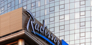 Radisson Hotel Group has reached a significant milestone in Africa, with more than 100 hotels across the continent in operation and under development. Radisson Blu continues to anchor the legacy footprint. At the same time, the Radisson brand is the fastest riser, supported by a strong conversion engine and a concrete pipeline that continues to translate into openings. Building on this momentum, the Group has signed over 15 new hotels and roughly 2,500 rooms in the last 12 months, including new market entries in the Democratic Republic of Congo and Zimbabwe. This week, Radisson Hotel Group is also attending FHS Africa (www.FutureHospitality.com) in Nairobi, reinforcing its commitment to expanding its presence and strengthening strategic partnerships across the continent. Over the past five years, Radisson and Radisson Blu have ranked among the most signed brands in Africa, with one of the highest shares of cumulative openings. The last 12 months set a new benchmark with more than 2,500 rooms signed and multiple market entries. Priority growth markets remain Morocco, South Africa, and Nigeria, where the Group is deepening its presence and widening its brand distribution. Ramsay Rankoussi, Regional Chief Development Officer, Radisson Hotel Group, commented: “We’ve crossed the 100-hotel mark in Africa by staying true to our plan, focusing on where we can lead, moving fast on quality conversions, and partnering with owners who share our ambition. The next phase is about depth in Morocco and Nigeria, a smarter footprint in South Africa, and a stronger resort offering that matches where travelers want to go. Our pipeline is built to open, not just to announce. That is why our conversion share is high, our time to market is short, and our brands are gaining ground in the cities and resort destinations that matter most.” Nigeria shows the model’s resilience. The Group now holds a strong position in the country with 13 hotels in operation and pipeline, while Abuja is carrying a significant active pipeline with three hotels totaling 458 keys. South Africa is being reshaped with priorities in Cape Town, targeted growth in secondary cities such as Durban and Pretoria, and a sharper focus on leisure corridors that include Kruger National Park, Sun City, and the Garden Route. The Group plans to enter Zanzibar and is considering lodge, safari, and affiliation opportunities across Namibia, Botswana, and Zambia to meet the rising demand for nature-led experiences. Conversions remain a core lever for scale and speed. In the last five years, more than 15 hotels, equal to almost 3,000 rooms, joined the portfolio through conversion. This helped the Group lead openings across the continent while keeping brand standards high and owners in mind. Recent signings show the extensiveness of this strategy, with a balanced pipeline of city hotels, resort destinations, and quick-to-market conversions. These signings span the Democratic Republic of Congo, Nigeria, Zimbabwe, and Morocco, including Radisson Blu Kinshasa and three Radisson hotels in Lubumbashi, Radisson Harare, Park Inn Victoria Falls, Radisson Collection Lagos Atlantic, as well as new additions in Casablanca with Radisson Blu Resort & Conference Center Bouskoura, a first Radisson brand hotel in Rabat, and further expansion in Marrakech. Key signings include: Democratic Republic of the Congo Radisson Blu Hotel, Kinshasa Upper-upscale flagship in Gombe Opening late 2026. Set on Boulevard Colonel Tshatshi in the Gombe district, the hotel will offer 110 keys, including suites and a Presidential Suite. Guests can choose from a lobby bar, an all-day dining restaurant, and a pool bar. Wellness includes a gym, massage rooms, and an outdoor pool with a terrace. Meetings and events feature a modern event hall with a pre-function area. The address is well connected, 32 kilometers from N’djili International Airport, 10 kilometers from N’Dolo Airport, and 6 kilometers from Gare Centrale. Radisson Hotel Lubumbashi Panoramic city stay in the DRC’s second city Opening mid-2027. Located on Revolution Road Avenue, the hotel will feature 97 keys, including junior suites and a Presidential Suite. Dining spans a lobby bar, an all-day dining venue, and a rooftop bar and grill with city views. Three flexible meeting rooms and a pre-function area support business and social events. Facilities include a gym and a swimming pool. The location sits near Kipopo Lake, Lubumbashi Golf Club, and La Plage, and is 12 kilometers from Luano International Airport. Radisson Blu Apartments Lubumbashi Upscale apartment living in Lubumbashi’s prestigious Quartier Golf Targeted for 2030. A 160-room property located in Quartier Golf, one of Lubumbashi’s most upscale residential districts, near Kipopo Lake and surrounded by luxury homes and key landmarks including Lubumbashi Golf and La Plage. Planned amenities include a specialty restaurant and bar, a pool bar, and a gym, offering a premium stay experience for extended-stay and leisure travelers. Radisson Airport Hotel Lubumbashi A strategically located airport hotel designed for ease and connectivity Set to open in 2028, this 105-room property will be located just 6 kilometers from Luano International Airport, around a 10-minute drive, making it well positioned for business travelers, transit guests, and airline crews. Planned facilities include a restaurant, lobby bar, pool bar, meeting rooms, and a swimming pool, combining practicality with a welcoming hospitality experience close to the airport. Egypt Radisson Resort Ain Sokhna Groove A large-scale Red Sea resort in one of Egypt’s growing leisure destinations Planned for 2029, Radisson Resort Ain Sokhna Groove will offer 469 rooms, including 50 family rooms, as part of The Groove Ain Sokhna mixed-use development. Located along the Red Sea coast, around 30 kilometers south of Ain Sokhna and approximately 150 kilometers from Cairo, the resort is expected to feature private beach access, a spa, gym and fitness center, several restaurants, plus a ballroom and meeting rooms, catering to both holidaymakers and events demand. Radisson Serviced Apartments COY Sheikh Zayed City Flexible extended-stay accommodation in a fast-growing hub of Greater Cairo Expected to open in 2030, this 120-key serviced apartments property, including six one-bedroom units, will form part of the COY development in Sheikh Zayed City. With a location just 13 kilometers from Sphinx International Airport and 14 kilometers from the Great Pyramids of Giza, the development sits close to major commercial, leisure, education, and healthcare destinations. Planned amenities include a coffee lounge, bar, kiosk, and meeting and event space integrated into the wider co-working environment. Morocco Radisson Blu Hotel & Conference Center, Casablanc a Bouskoura Conference-ready address beside Palm Golf A 119-key hotel with eight suites, a rooftop restaurant, and a dedicated conference center. Event facilities include two boardrooms, while a spa and a large outdoor pool cater to leisure travelers. The hotel is located 20 kilometers from Mohammed V International Airport and next to Palm Golf Palmeraie Country Club. Radisson Hotel & Apartments Rabat Technopolis Dual-component hub in the capital’s innovation park A two-building project in Technopolis, 25 minutes from central Rabat. The hotel will offer 140 rooms, four dining venues, a pool, and a meeting and events space. The adjacent serviced apartment building adds 56 units. Technopolis connects businesses with leading education and research centers, creating a strong base for corporate demand. Radisson Blu Resort Marrakech Ben Akil Low-rise bungalows with views of Atlas Mountains Opening early 2028. A 17-hectare estate featuring 80 bungalow-style accommodations, each with an outdoor terrace. Larger typologies include private pools. The resort sits beside Royal Golf Marrakech and is a 15-minute drive from the city center. Nigeria Radisson Hotel Aba A new internationally branded hospitality destination for Aba Targeted for 2031, Radisson Hotel Aba will introduce 120 rooms, including six junior suites, in a prime riverside location along the Aba River near key transport corridors. The hotel will become the first Radisson-branded property in Aba and the Group’s third branded hotel in Nigeria. Plans for the hotel include a gym, swimming pool, and several meeting rooms, serving both business and local demand. Sam Mbakwe International Airport in Owerri is approximately 56 kilometers away, or a 1 hour and 10 minute drive. Radisson Hotel & Conference Center Yenagoa A conference-focused hotel in the heart of an emerging Nigerian business center Scheduled for 2027, the property will feature 196 rooms, including 16 junior suites, four executive suites, and two Presidential Suites, in Yenagoa, a city that is steadily strengthening its role as an administrative and commercial hub in southern Nigeria. Located near government institutions, business districts, and Bayelsa International Airport, approximately 33 kilometers or 40 minutes away, the hotel is set to benefit from the area’s ongoing infrastructure and hospitality growth while meeting rising demand for accommodation, meetings, and large-scale events. Radisson Collection Hotel, Lagos Atlantic Refined lifestyle luxury on the oceanfront of Lagos’ leading business district Targeted for 2029, Radisson Collection Hotel, Lagos Atlantic will feature 107 rooms, including 16 executive suites and one Presidential Suite, on a prime oceanfront site on Victoria Island. As Lagos’ main financial and commercial district, Victoria Island is home to multinational companies, corporate headquarters, embassies, and strong year-round business activity. Located approximately 33 kilometers from Murtala Muhammed International Airport, around a 45-minute drive, the hotel will mark the second Radisson Collection property in Lagos. South Africa Radisson Serviced Apartments Umhlanga A modern serviced apartment offering in the heart of Umhlanga’s business district Planned for 2029, Radisson Serviced Apartments Umhlanga will introduce 155 rooms in a newly built development within Umhlanga Ridge, one of the area’s most established commercial and lifestyle hubs. The property will be within walking distance of Gateway Theatre of Shopping and close to major office precincts, including Umhlanga Ridge Business Park, La Lucia Office Park, and Glass House Office Park. Comprising studios and apartments, the project is designed to meet growing demand for high-quality extended-stay accommodation in the district. Zimbabwe New market entry Radisson Serviced Apartments, Harare Prime Borrowdale address for extended stays Targeted for end-2028. A 147-key serviced apartments project within a master development near Maxwell Road in Borrowdale. The neighborhood is known for luxury residences, upscale shopping at Sam Levy’s Village, and entertainment at Borrowdale Racecourse. Planned amenities include a café and bar, a gym with sauna, and a pool with a deck. Set to be the only internationally branded hotel apartment offering in the area. Park Inn by Radisson Victoria Falls Resort A resort destination near one of the world’s most iconic natural landmarks Expected to open in 2029, Park Inn by Radisson Victoria Falls Resort will offer 150 rooms, including five suites, in a setting overlooking Zambezi National Park. Located just 5 kilometers from Victoria Falls, around a 10-minute drive, the resort will be ideally positioned near one of the Seven Natural Wonders of the World, a destination that attracts more than 350,000 international visitors each year. With year-round waterfall views, adventure tourism, and access to safari experiences in the surrounding national parks, the property will cater to both leisure travelers and tour groups. Victoria Falls Airport is located approximately 22 kilometers, or a 23-minute drive, away. Leading with the most diverse footprint across the continent, with presence in more than 30 African countries, Radisson Hotel Group blends depth in focus markets with selective entry into new destinations each year.